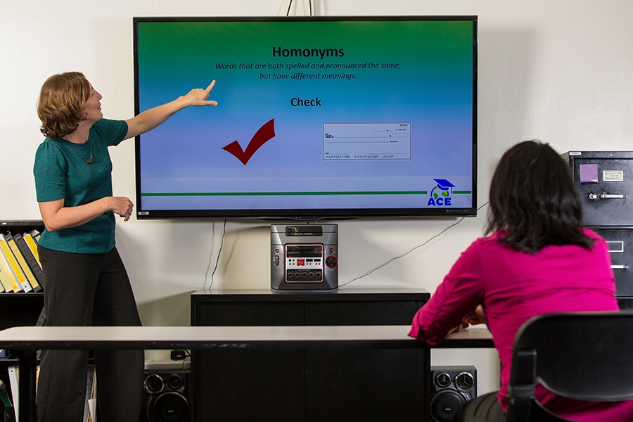 ACE English Teacher Christine Poreba teaches in front of screen